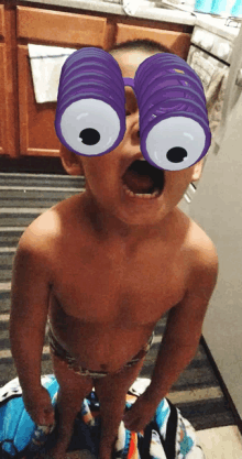 a little boy wearing a pair of purple glasses