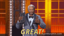 a man in a suit and bow tie holding a book and a trophy with the words " great " above him