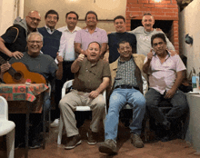 a group of men are posing for a picture and one of them is wearing a huge shirt