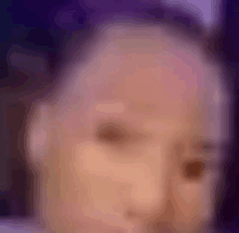 a blurry picture of a person 's face with purple background .