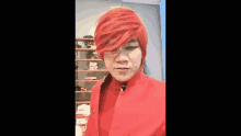 a man with red hair is wearing a red jacket and a red wig