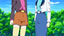 two anime characters standing next to each other in front of trees