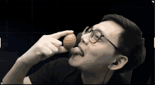 a man wearing glasses is holding an egg in his hand