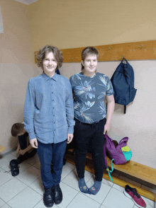 two boys are standing next to each other in a room