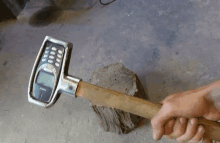 a person is holding a hammer with a nokia cell phone attached to it