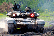 a military tank is driving through a field with red lights on the front