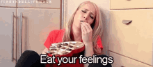 a woman is sitting on the floor with a plate of chocolates and the words " eat your feelings " above her .