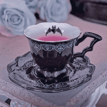 a cup of tea with a bat on it is on a saucer .