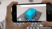 a person holding a cell phone with a 3d model of a table on the screen