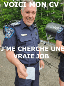 a police officer holding a piece of paper with the words voici mon cv written on it