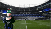 a man wearing a beanie that says legia stands in front of a soccer field