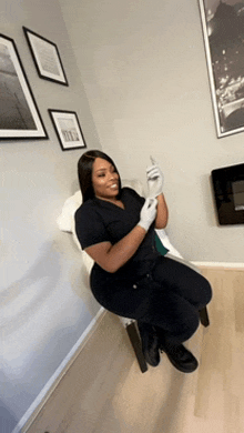 a woman is sitting on a chair holding a syringe in her hand .