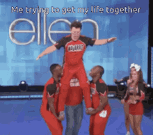 a cheerleader is carrying another cheerleader on his shoulders in front of an ellen show