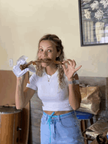 a woman in a white shirt is eating a piece of meat