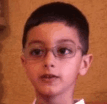 a close up of a young boy wearing glasses .