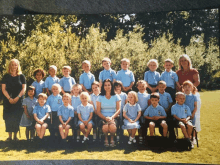 a group of children are posing for a picture with their teacher