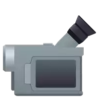 an icon of a video camera with a black lens on a white background