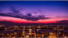 an aerial view of a city at night with a purple sky