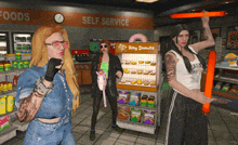 three women are standing in front of a display of king donuts