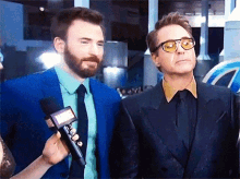 chris evans and robert downey jr. are being interviewed by a woman