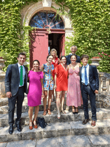 a group of people standing in front of a red door