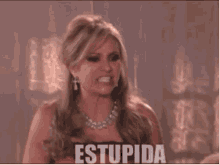 a woman in a red dress is making a funny face and the word stupida is on the screen