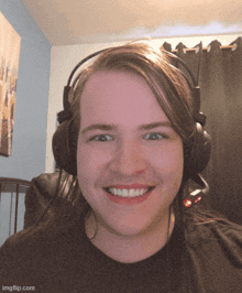 a man wearing headphones is smiling for the camera with imgflip.com at the bottom