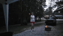 a woman in red shorts is holding a torch