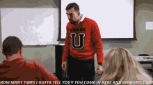 a man in a red chase sweater stands in front of a group of people