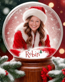 a woman in a santa suit is in a snow globe with the name robin written on it