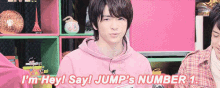 a young man in a pink hoodie is saying i 'm hey ! say ! jump 's number 1 .