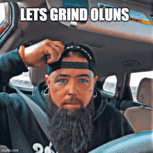 a man with a beard is sitting in a car with the words let 's grind olsuns written above him