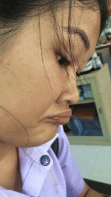 a close up of a woman 's face with a button on her shirt