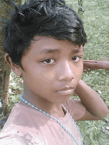 a young boy with a necklace around his neck