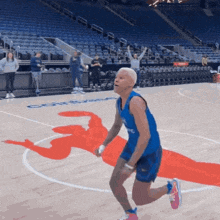 a man in a blue jersey is running on a basketball court in front of a sign that says courthouse