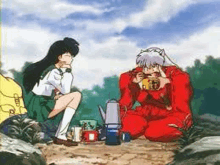 a man and a woman are sitting next to each other on a rock eating food .