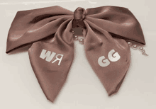 a brown bow with the letters w and g embroidered on it