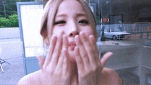 a woman is blowing a kiss with her hands