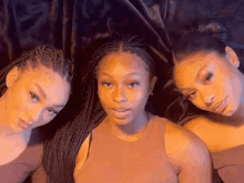 three women with braids are posing for a picture .