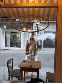 a man smoking a cigarette in front of a store that says l' instant present