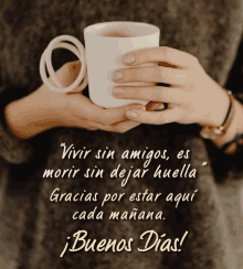 a woman is holding a cup of coffee and a quote in spanish