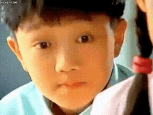 a close up of a child 's face with a braided hair .