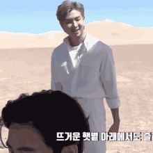 a man in a white shirt stands in a desert