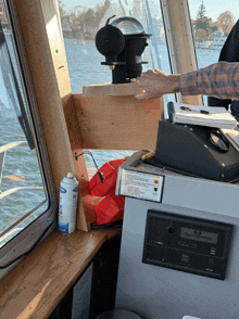 a man adjusts a device on a boat that says " autosense " on it