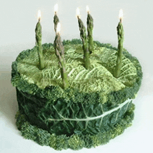 a cake made out of cabbage and asparagus with candles on it