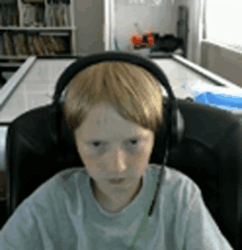 a boy wearing headphones is sitting in a chair