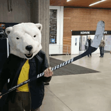 a man in a polar bear mask holding a hockey stick with the word warrior on it