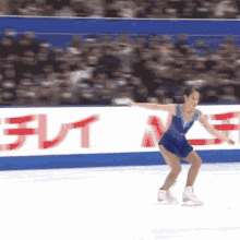 a woman in a blue dress is ice skating in front of a sign that says ' a ' on it