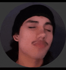 a young man with a mustache wearing a black beanie