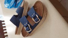 a pair of blue sandals with gold buckles on a table